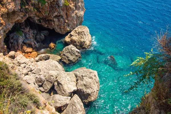 Top view of the rock and blue sea water. In the rock there is a large cave which is flooded with sea water. Beautiful nature in a country with a warm tropical climate.