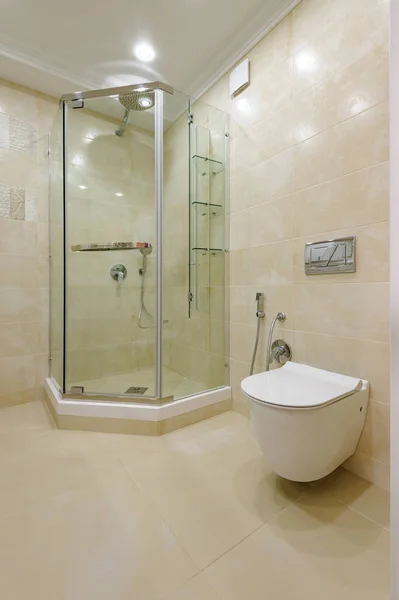 Светлый санузел со стеклянным душем и туалетом — стоковое фото