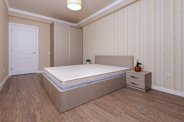 Новая пустая коричневая спальня с двуспальной кроватью и тумбочками — стоковое фото