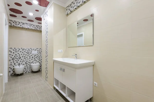 Wnętrze łazienki, szafki z lustrem, toaleta oraz bidet — Zdjęcie stockowe