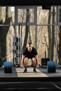 Deadlift girişimi. Ağır halter kaldırmak çalışan genç adam