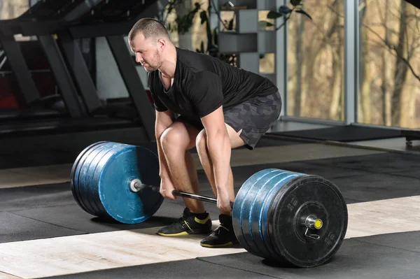 Tentativa de deadlift. Jovem tentando levantar pesado barbell — Fotografia de Stock