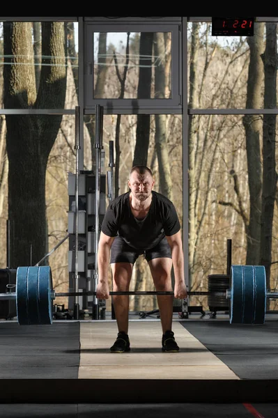 Marklyft-försök. Ung man som försöker lyfta tung skivstång — Stockfoto