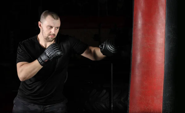 Entrenamiento de boxeador en un saco de boxeo en el gimnasio —  Fotos de Stock