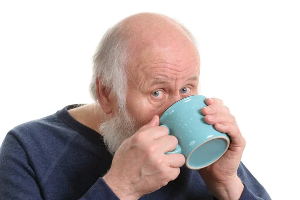 Starší muž pití z hrnku, izolované na bílém — Stock fotografie