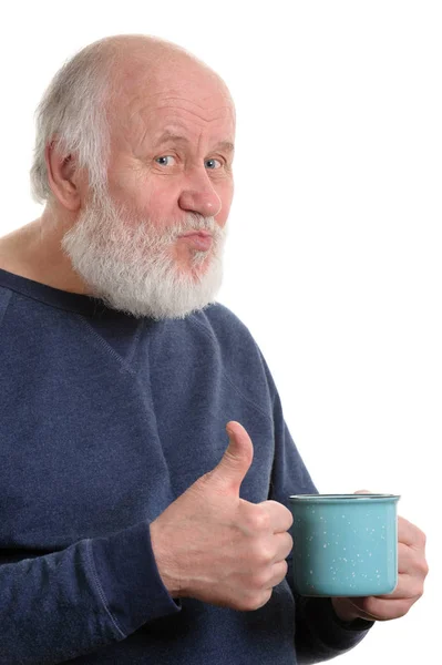 Elderly man with cup of bad tea or coffee showing thumb up isolated on white — Stock Photo, Image