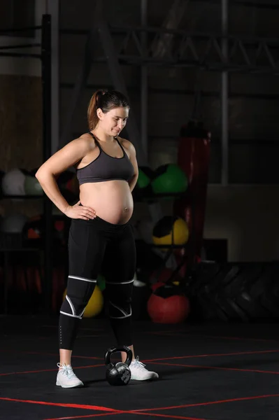 Gravid kvinna idrottsman gör hantel power snatch — Stockfoto