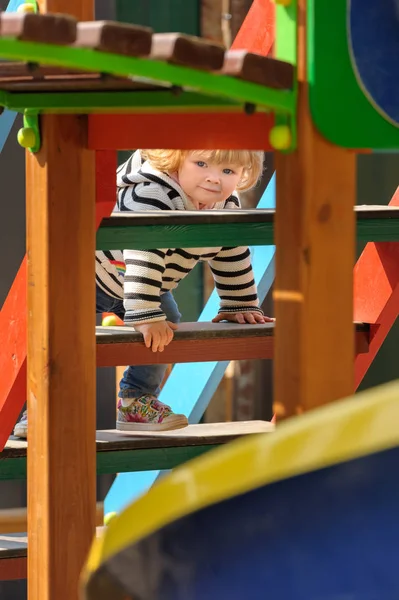 Cute little toddler girl climbing stairs of a childrens slide — Stock Photo, Image