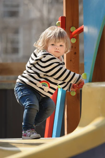 Cute little toddler girl almost sliding down the childrens slide — Stock Photo, Image