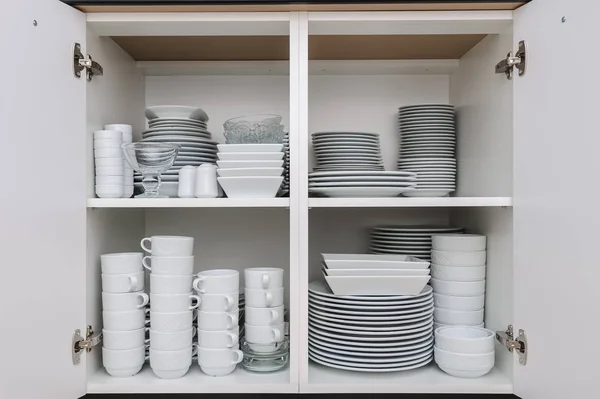 Dishware storage cabinet with plates and cups inside — Stock Photo, Image