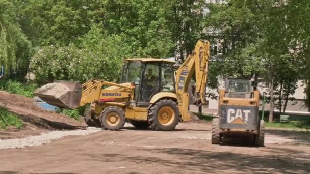 Two skid steer loaders moving sand soil at construction area outdoors — Stock Video