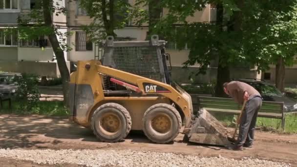 屋外の建設エリアで砂の土壌を移動するスキッドステアローダー — ストック動画