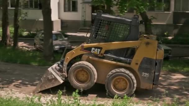 Skid φορτωτής κατευθύνουν κινούμενη άμμο εδάφους στην περιοχή κατασκευής σε εξωτερικούς χώρους — Αρχείο Βίντεο