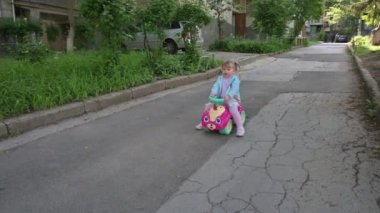 Parkta oyuncak araba süren bir çocuk.