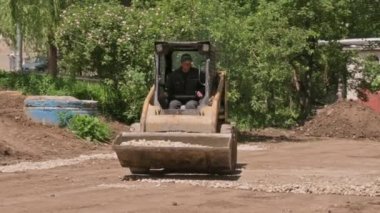 Dümen yükleyicisi inşaat alanında kum toprağı taşıyor.