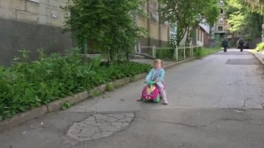 Parkta oyuncak araba süren bir çocuk.