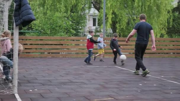 Bambini di tutte le età che giocano a calcio AKA gioco di calcio nel quartiere residenziale — Video Stock