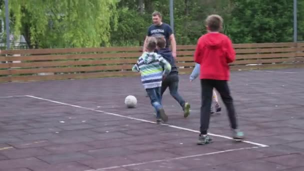 Crianças de todas as idades jogando futebol AKA jogo de futebol no bairro residencial — Vídeo de Stock