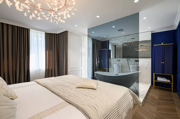 Duże wygodne łóżko podwójne w eleganckiej klasycznej sypialni — Zdjęcie stockowe