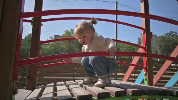 Pequena menina loira foge no parque infantil — Vídeo de Stock