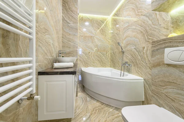 Baño de lujo con bathub blanco y baldosas de mármol beige —  Fotos de Stock