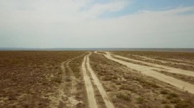 Kazakistan çamurlu nehir bozkırlarında yolda. Görünüm ufuk kadar çok uzun yolda. Sınırsız Kazakistan bozkırlarında Gölü kurudu. Alansal Dron ateş.