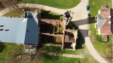 Letonya, Avrupa 'daki Havadan Yok Edilmiş Odzienas Şatosu Güzel Güneşli bir Bahar Günü, Kırsal kesimde Uyum içinde Seyahat kavramı. Antik Kale 'nin ayrıntıları. Kuledeki Leylek Yuvası