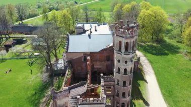 Letonya, Avrupa 'daki Havadan Yok Edilmiş Odzienas Şatosu Güzel Güneşli bir Bahar Günü, Kırsal kesimde Uyum içinde Seyahat kavramı. Antik Kale 'nin ayrıntıları. Kuledeki Leylek Yuvası