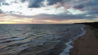 Dron, Backgroiund 'da güzel bir Kiteserfing' le Deniz Üzerinde Uçuyor. Hava Aracı Atışı. Denizin Üzerinde Gün Doğumu. Letonya, Baltık Denizi 'nde Renkli Gün Batımı.