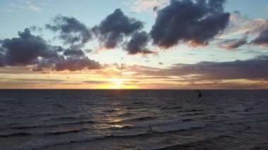 Dron, Backgroiund 'da güzel bir Kiteserfing' le Deniz Üzerinde Uçuyor. Hava Aracı Atışı. Denizin Üzerinde Gün Doğumu. Letonya, Baltık Denizi 'nde Renkli Gün Batımı.