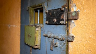 Hapishanenin Metal Kapı Pencereleri Mahkumu İçeriden Kaçışa Koruyun. Yemek Kanalı hapishane parmaklıklarından geçiyor. Hapis, Hapis ve Suç Detayları, Adalet. Hapishane içinde. Özgürlüğü Sınırlama Kavramı.