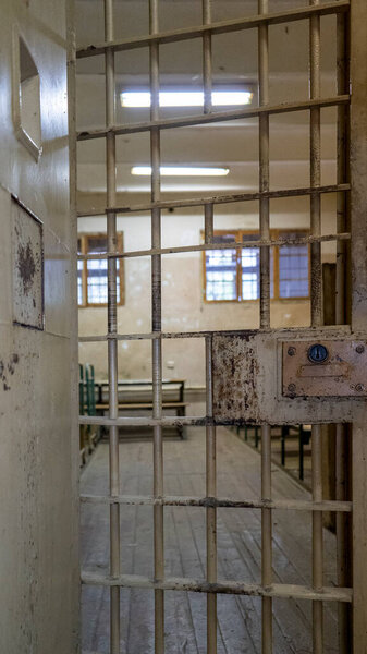 Окна тюрьмы из металлической двери защищают заключённого изнутри от побега. Продовольственный канал через тюремные камеры. Тюрьма, Деталь заключения и преступления, Правосудие. Тюремный интерьер. Концепция ограничения свободы.