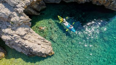 Bikini 'deki Güzel Genç Kadın, Hırvatistan' ın Stara Baska Sahili Krk Adası 'nda yüzüyor. Akdeniz Yazı. Yukarıdan havadan ateş edildi. Mavi Deniz Kayalık Dağlar ve Sahil Kıyısı Açık Mavi Suyla