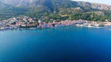 Krk Adası, Hırvatistan Adriyatik Denizi, Vela Plaza Sahili, Dağlar ve Kamp Kenti manzaralı Baska Sahili Açık Turkuaz Suyu, Marina Tekneleri, Şehir Caddesi, Güneşli Yaz Günbatımı Hava Manzarası