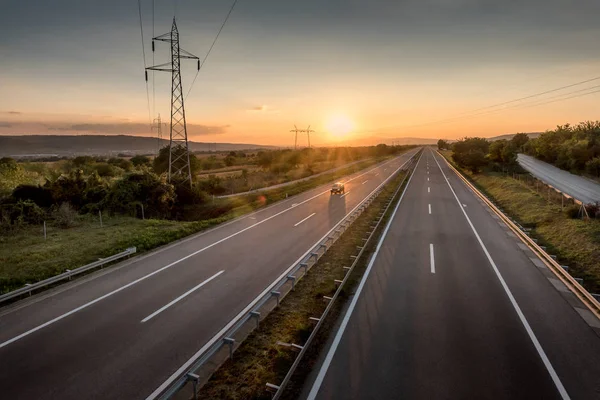 单车在一个美丽的寂静的乡村高速公路和电线在日落 — 图库照片