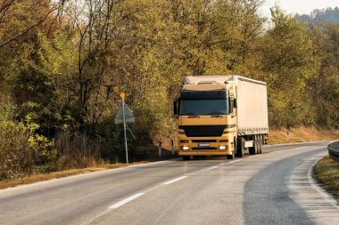 Bir dağ yolda sarı kamyon taşıyıcı