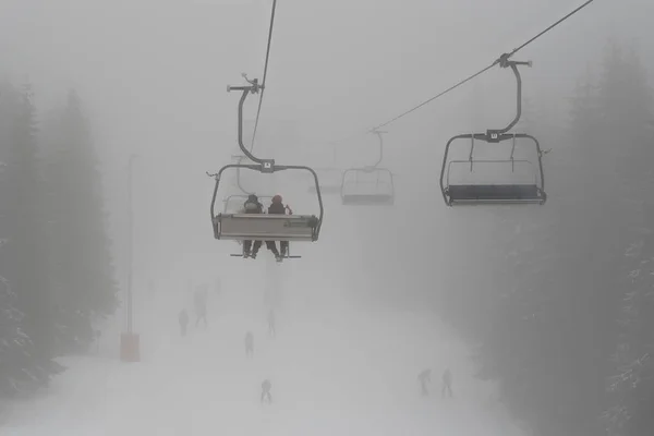 Sessellift Mit Skifahrer Silhouetten Mit Einer Skipiste Unten Tiefen Nebel — Stockfoto