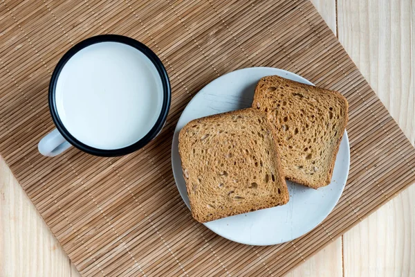 Δύο Φέτες Τοστ Ψωμί Και Κασσίτερος Κούπα Γάλακτος Μια Ξύλινη — Φωτογραφία Αρχείου