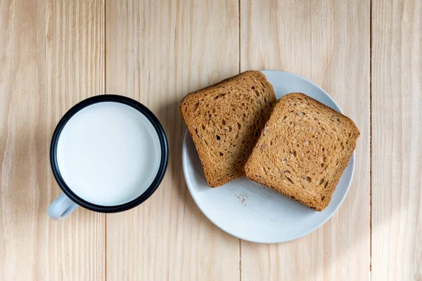 Dos Rebanadas Pan Tostado Una Taza Leche Una Mesa Madera —  Fotos de Stock