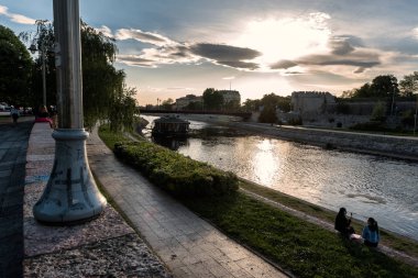 Niş, Sırbistan - 3 Mayıs 2019: Niş kalesi ve üniversite binası, Nisava nehri kıyısında yüzen kahve barı ile. Nis, Sırbistan'ın üçüncü büyük şehri, Avrupa