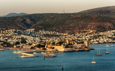 Türk Rivierası 'ndaki Bodrum Kalesi ve yat limanının panoramik günbatımı manzarası. Bodrum, Ege Bölgesi 'nin güneybatısında, Mugla ilinin bir liman kentidir.