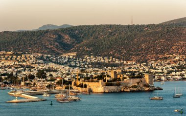 Türk Rivierası 'ndaki Bodrum Kalesi ve yat limanının panoramik günbatımı manzarası. Bodrum, Ege Bölgesi 'nin güneybatısında, Mugla ilinin bir liman kentidir.