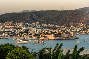 Türk Rivierası 'ndaki Bodrum Kalesi ve yat limanının panoramik günbatımı manzarası. Bodrum, Ege Bölgesi 'nin güneybatısında, Mugla ilinin bir liman kentidir.