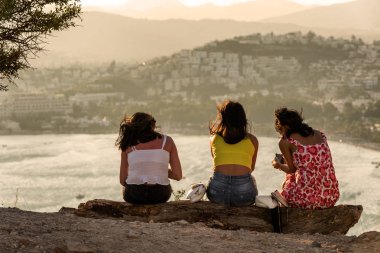 Bodrum, Türkiye - 21 Ağustos 2019. Kız arkadaşlar Gumbet Bay 'de güzel ve rahatlatıcı gün batımı manzarasının keyfini çıkarıyorlar. Bodrum. Mugla ili, Türkiye.