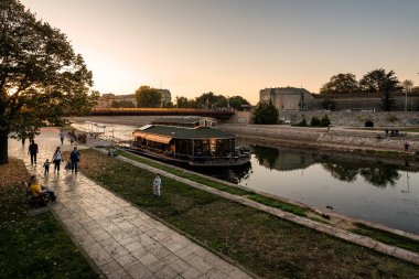 Nis, Sırbistan - 3 Mayıs 2019: Nis kalesi ve üniversite binası ile birlikte güzel gün batımında Nisava nehrinin kıyısında Sırp Şehri. Nis, Sırbistan ve Avrupa 'nın üçüncü büyük kentidir.