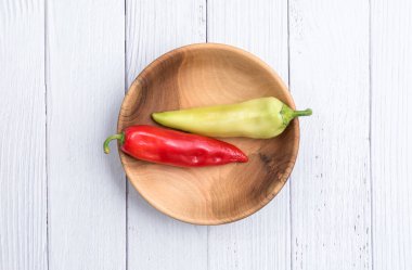 Ahşap bir kasede kırmızı ve yeşil biber. Olgun biberler. Yakın çekim. Boşluğu kopyala.