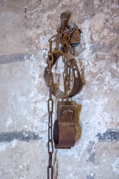 Old rusty shackles with chain on wall in prison — Stock Photo, Image