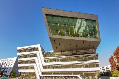 Viyana Ekonomi ve İş Üniversitesi ikonik Kütüphane ve Öğrenim Merkezi 'nin canlı, güneşli bir dış görünüşü