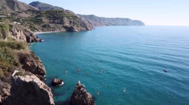 Büyük grup İspanya Nerja yakınındaki güzel sahil şeridi üzerinde denizde Kano insan hava atış
