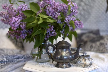 Çaydanlık ve bir demet leylak. Çay için çaydanlık ve cam bardaklardan güzel bir demet leylak..